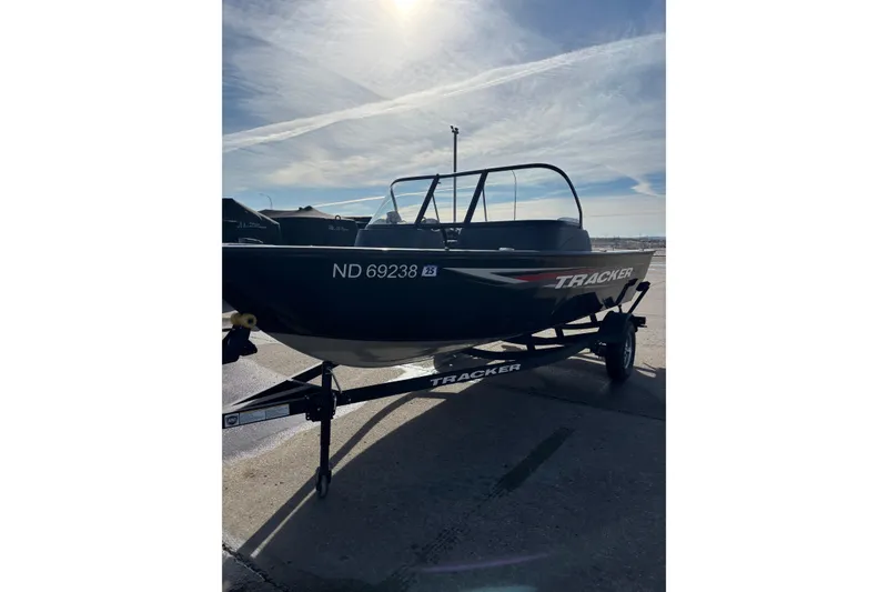 Slide: The Image of 2025 Tracker Pro Guide V-16 WT boat on trailer under sunny sky. - 5