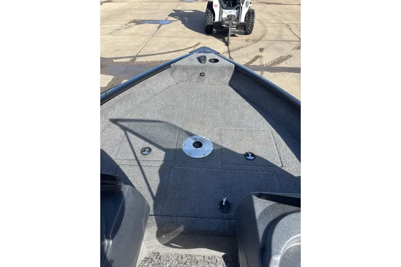 Slide: The Image of 2025 Tracker Pro Guide V-16 WT boat deck with gray carpeting and fishing seat base. - 8