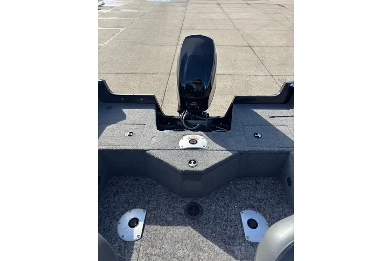 Slide: The Image of 2025 Tracker Pro Guide V-16 WT boat interior with motor, gray carpeted deck. - 9