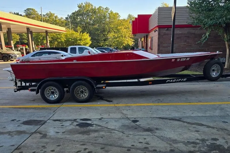 Slide: The Image of 1975 Sleekcraft Executive 23 boat on trailer at a gas station. - 11