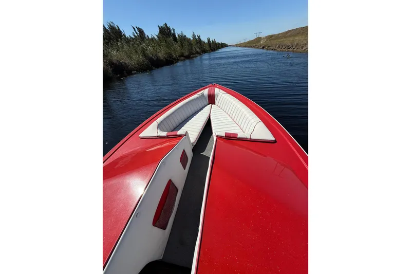 Slide: The Image of Red 1975 Sleekcraft Executive 23 boat cruising on a narrow waterway. - 4