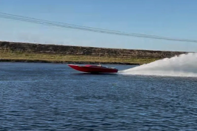 Slide: The Image of Red 1975 Sleekcraft Executive 23 speedboat cruising on a calm lake. - 6