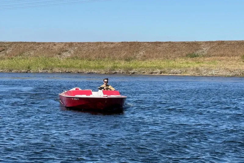 Slide: The Image of 1975 Sleekcraft Executive 23 boat cruising on a sunny day in a calm waterway. - 7
