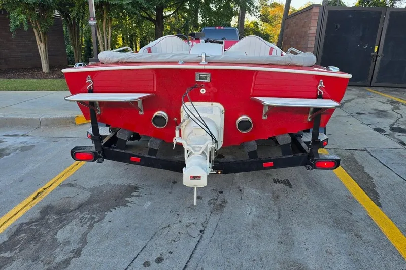 Slide: The Image of 1975 Sleekcraft Executive 23 boat, red exterior, parked on a trailer in a lot. - 8