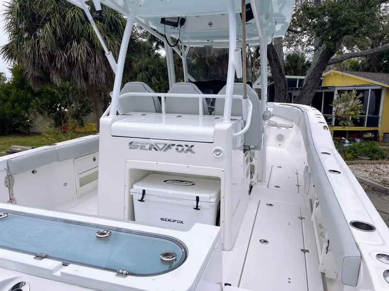 Slide: The Image of 2019 Sea Fox 328 Commender boat, white deck, palm trees in background. - 16