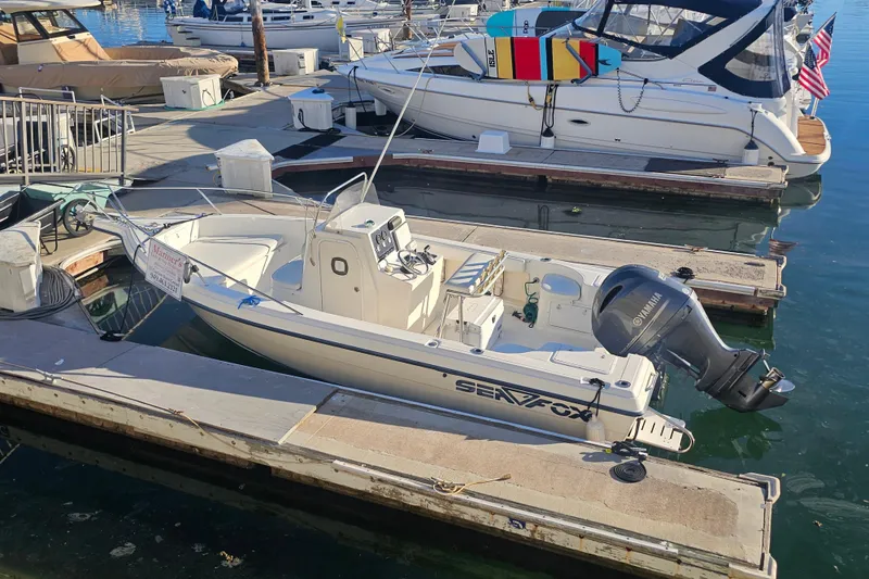 The Image of 2002 Sea Fox 210 Center Console boat docked at a marina with Yamaha outboard motor. - 0