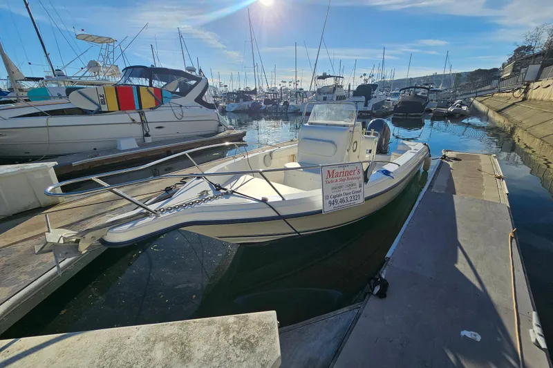 Slide: The Image of 2002 Sea Fox 210 Center Console boat docked in a marina under clear skies. - 3