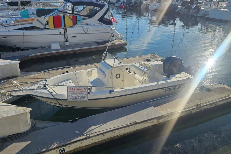 Slide: The Image of 2002 Sea Fox 210 Center Console boat docked at marina under sunlight. - 4