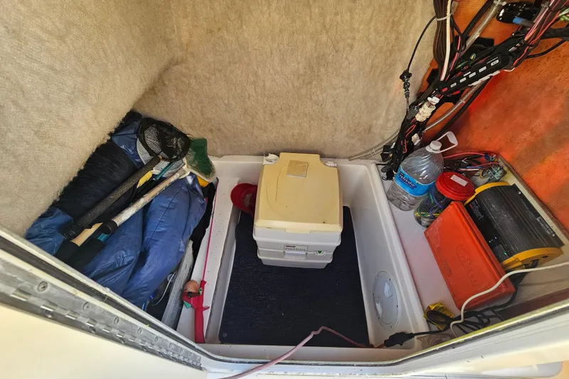 Slide: The Image of Storage compartment of a 2002 Sea Fox 210 Center Console boat with fishing gear and supplies. - 8