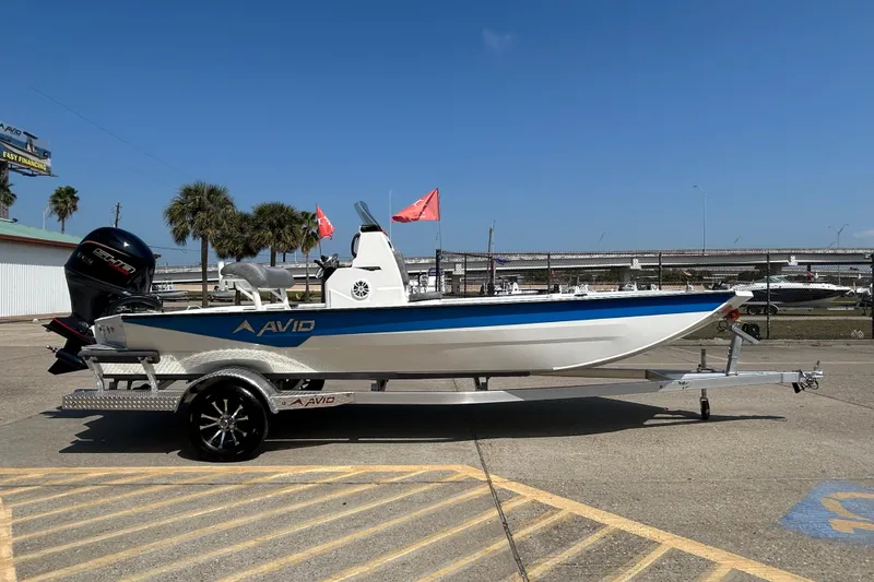 Slide: The Image of 2026 Avid 21 Recon boat on trailer, parked outdoors under clear blue sky. - 4
