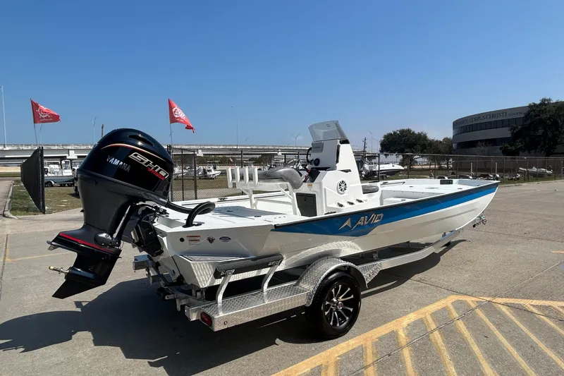 Slide: The Image of Avid 21 Recon 2026 boat with Yamaha engine on a trailer in a parking lot. - 5