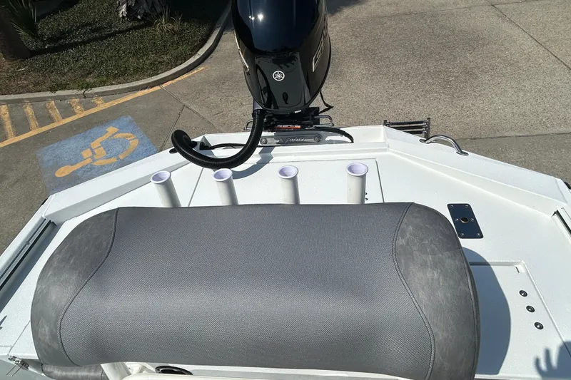 Slide: The Image of Avid 21 Recon 2026 boat with motor and seating, parked near a handicap space. - 7