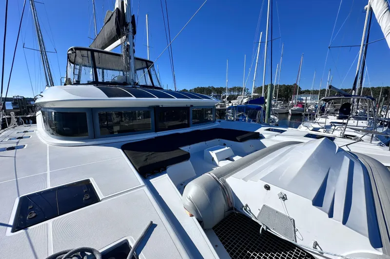 Slide: The Image of 2023 Lagoon 50 catamaran docked at marina under clear blue sky. - 12