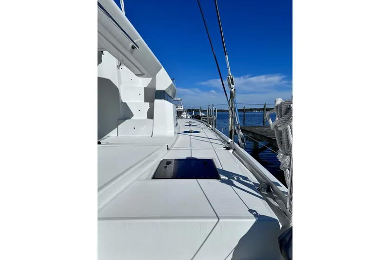Slide: The Image of 2023 Lagoon 50 yacht deck with clear blue sky and marina view. - 14