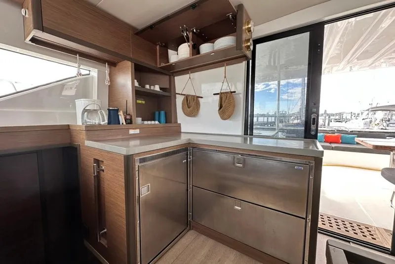Slide: The Image of Modern kitchen interior of 2023 Lagoon 50 yacht with stainless steel appliances and wooden cabinetry. - 24