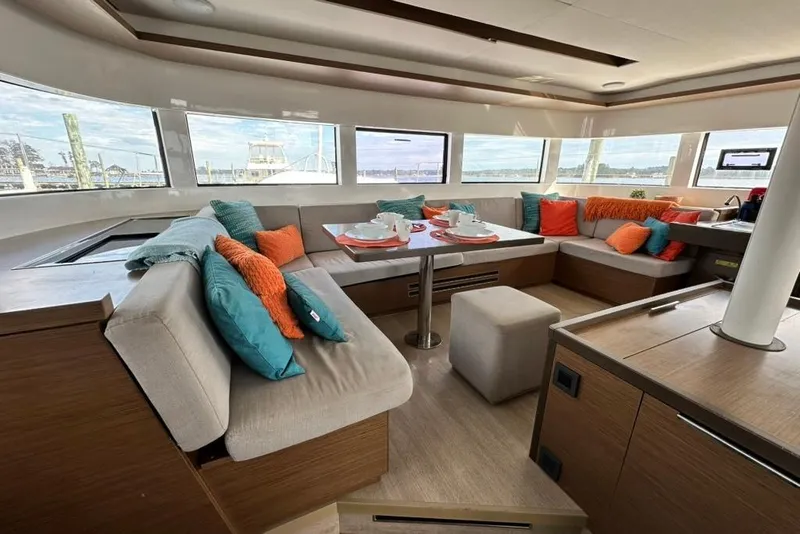 Slide: The Image of Luxurious interior of 2023 Lagoon 50 catamaran with colorful cushions and panoramic windows. - 25