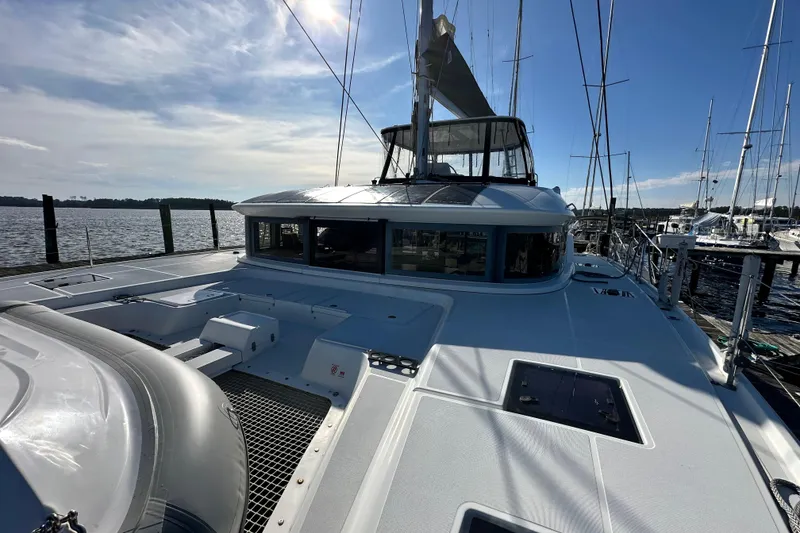 Slide: The Image of 2023 Lagoon 50 catamaran docked at marina under clear blue sky. - 39