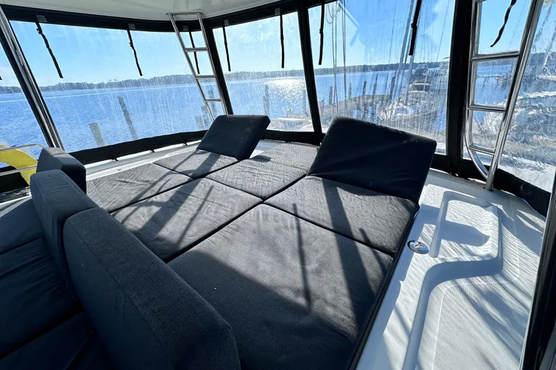 Slide: The Image of 2023 Lagoon 50 yacht interior with sunlit lounge area and panoramic windows. - 4