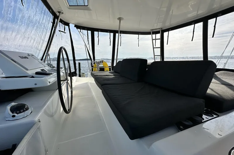 Slide: The Image of 2023 Lagoon 50 yacht interior with steering wheel and cushioned seating. - 41