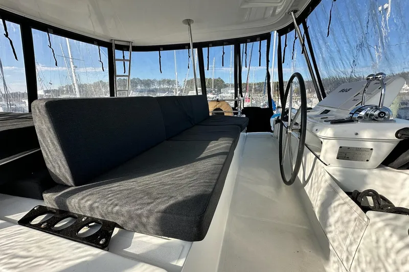Slide: The Image of 2023 Lagoon 50 yacht cockpit with seating and steering wheel, featuring panoramic windows. - 42