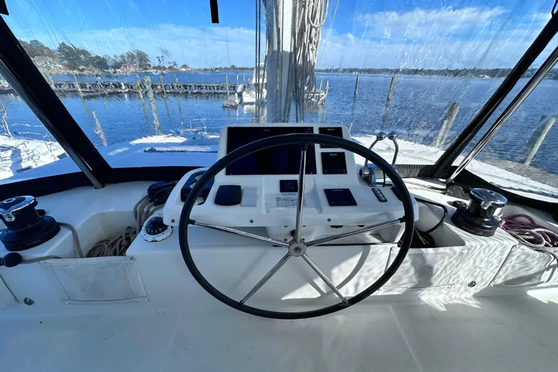 Slide: The Image of Cockpit of 2023 Lagoon 50 catamaran with steering wheel and navigation controls. - 5