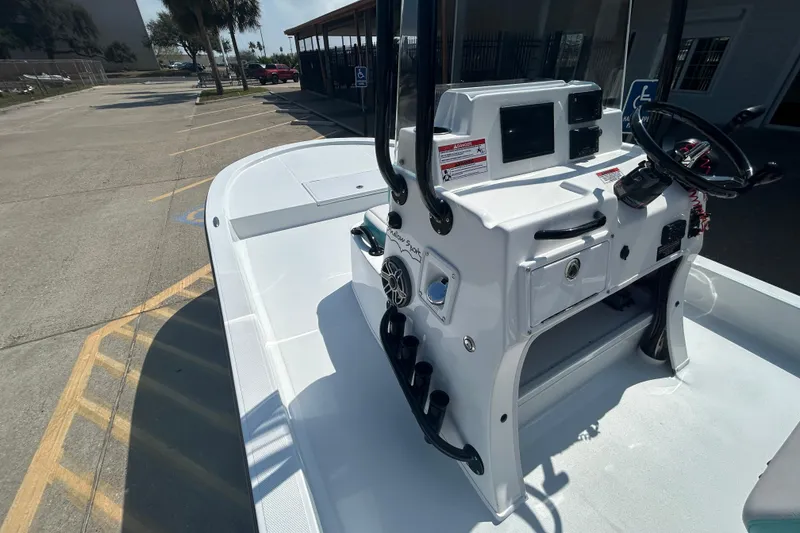 Slide: The Image of 2026 Shallow Sport 18 Sport boat with modern console and steering wheel in a parking area. - 12