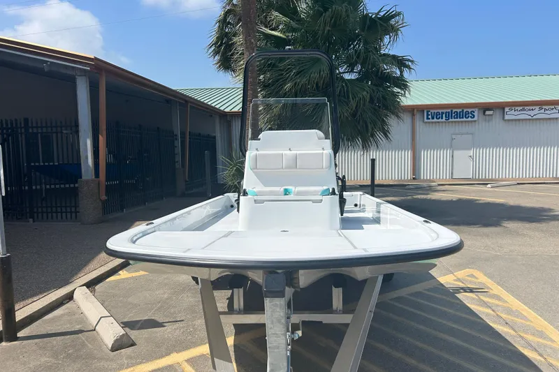 Slide: The Image of 2026 Shallow Sport 18 Sport boat on trailer, parked outdoors near palm trees. - 3