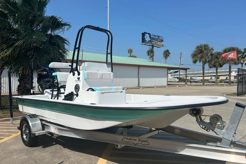 Slide: The Image of 2026 Shallow Sport 18 Sport boat on trailer, parked outdoors near palm trees. - 4
