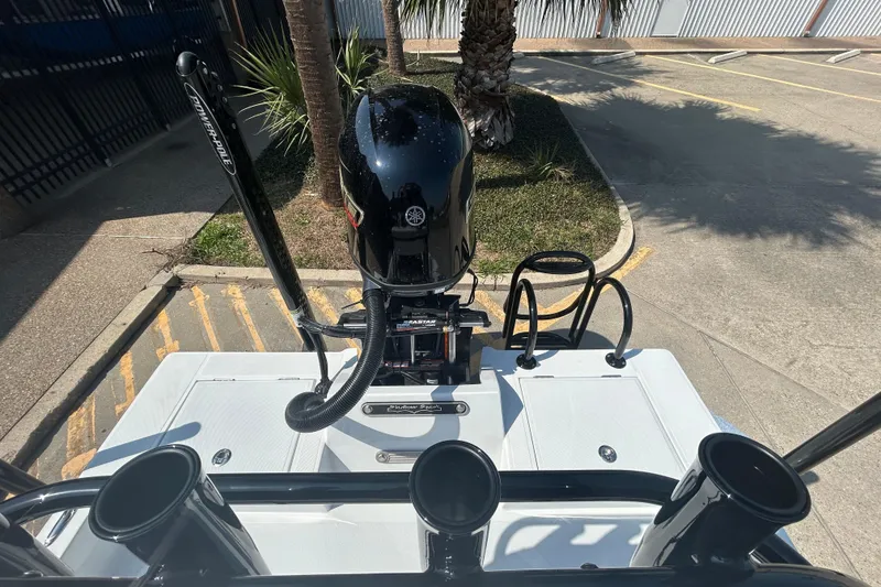 Slide: The Image of 2026 Shallow Sport 18 Sport boat with outboard motor and Power-Pole in a parking area. - 7