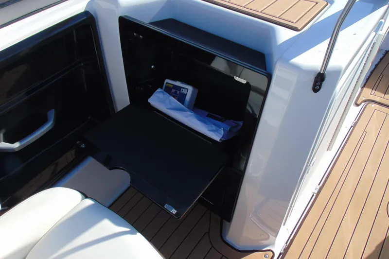 Slide: The Image of 2022 Yamaha Boats 212SE interior storage compartment with open hatch and visible contents. - 12