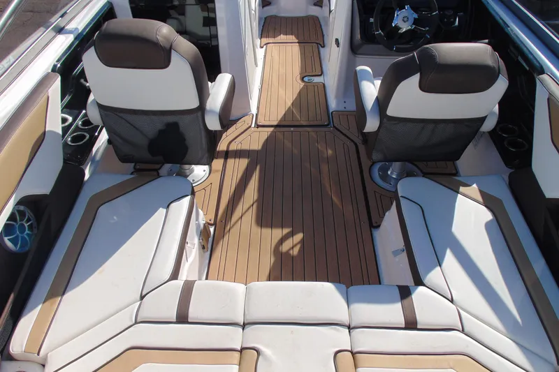 Slide: The Image of 2022 Yamaha Boats 212SE interior with stylish seating and wood-like flooring. - 8