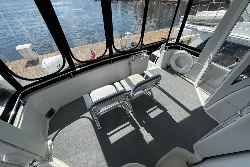 Slide: The Image of 2004 Carver 444 Cockpit Motor Yacht interior with chairs, overlooking water. - 10