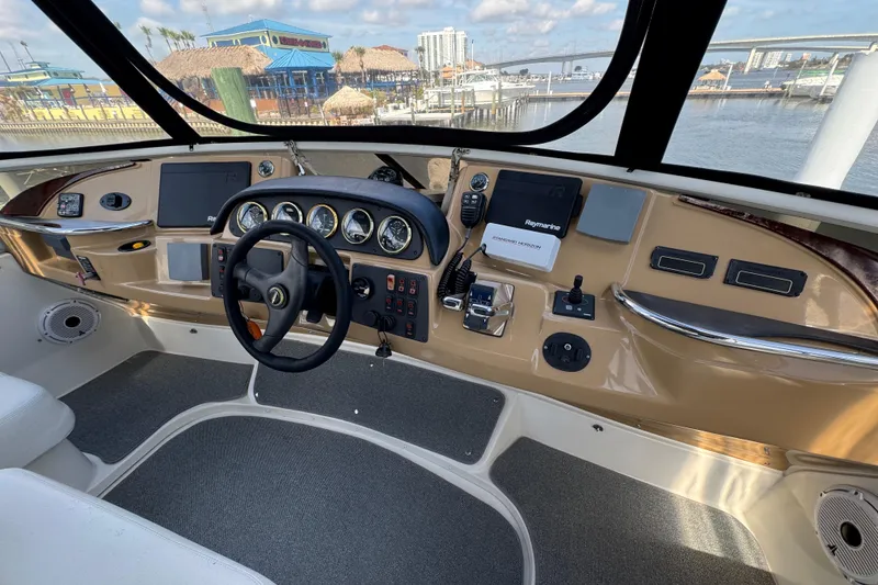 Slide: The Image of 2004 Carver 444 Cockpit Motor Yacht helm with modern navigation equipment and waterfront view. - 12
