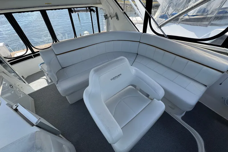 Slide: The Image of Luxurious interior of 2004 Carver 444 Cockpit Motor Yacht with white seating and waterfront view. - 13