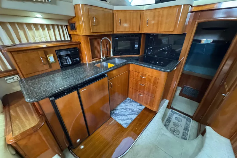 Slide: The Image of Luxurious 2004 Carver 444 Cockpit Motor Yacht kitchen with wood cabinetry and modern appliances. - 27