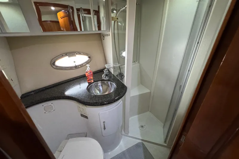 Slide: The Image of 2004 Carver 444 Cockpit Motor Yacht bathroom with sink, shower, and porthole window. - 32