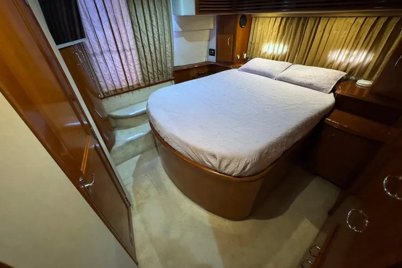 Slide: The Image of 2004 Carver 444 Cockpit Motor Yacht bedroom with cozy bed and elegant wood finish. - 38