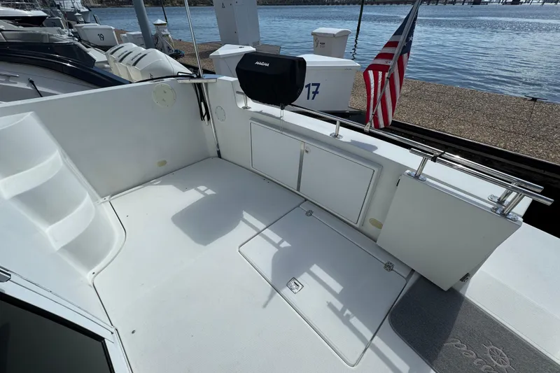 Slide: The Image of 2004 Carver 444 Cockpit Motor Yacht with American flag, docked by the water. - 4