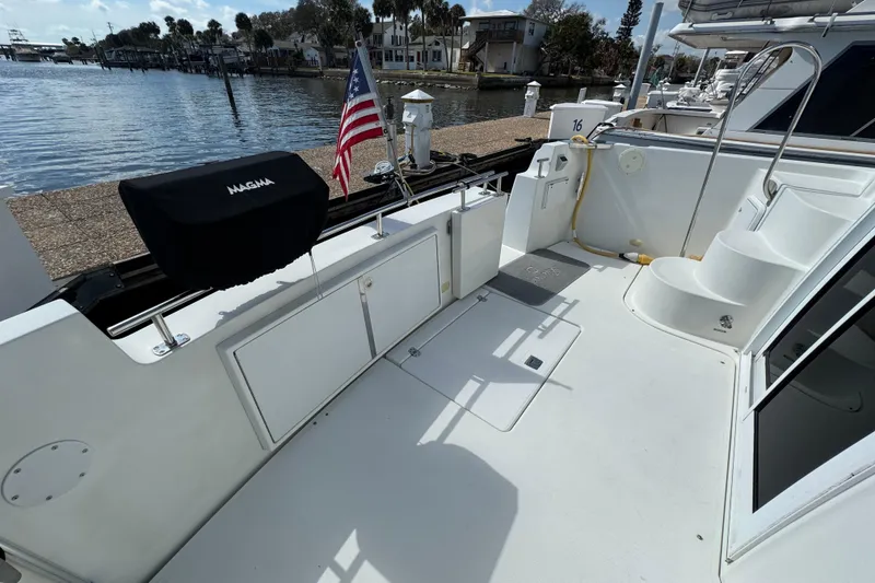 Slide: The Image of 2004 Carver 444 Cockpit Motor Yacht with spacious deck, docked by waterfront. - 5