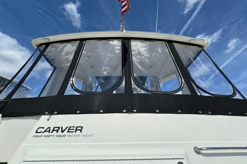 Slide: The Image of 2004 Carver 444 Cockpit Motor Yacht with clear enclosure, under a blue sky. - 6