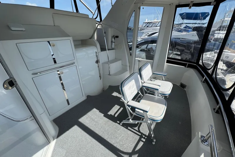 Slide: The Image of 2004 Carver 444 Cockpit Motor Yacht interior with seating and storage, docked at marina. - 8