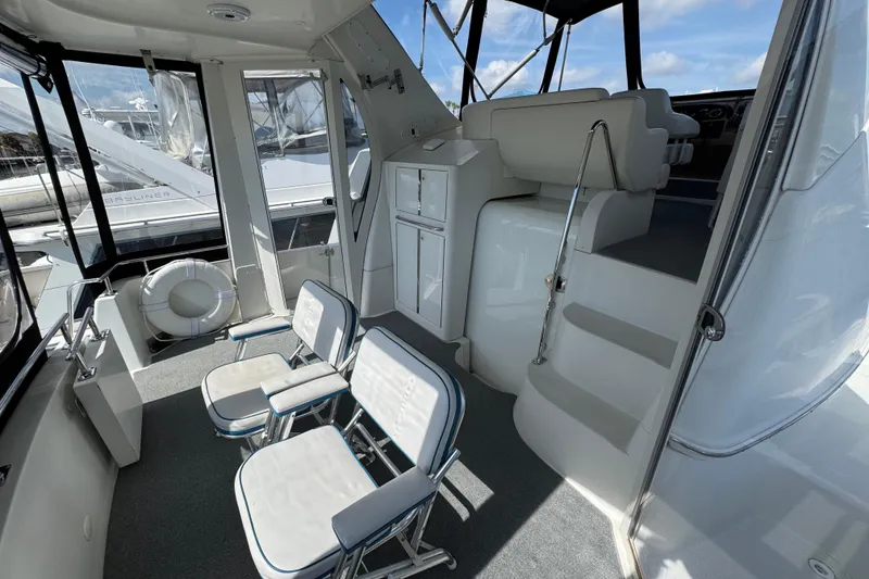 Slide: The Image of 2004 Carver 444 Cockpit Motor Yacht interior with seating and stairs, featuring a bright, spacious design. - 9