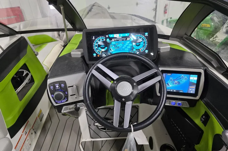 Slide: The Image of 2018 Malibu Wakesetter 22 MXZ dashboard with advanced digital controls and steering wheel. - 3