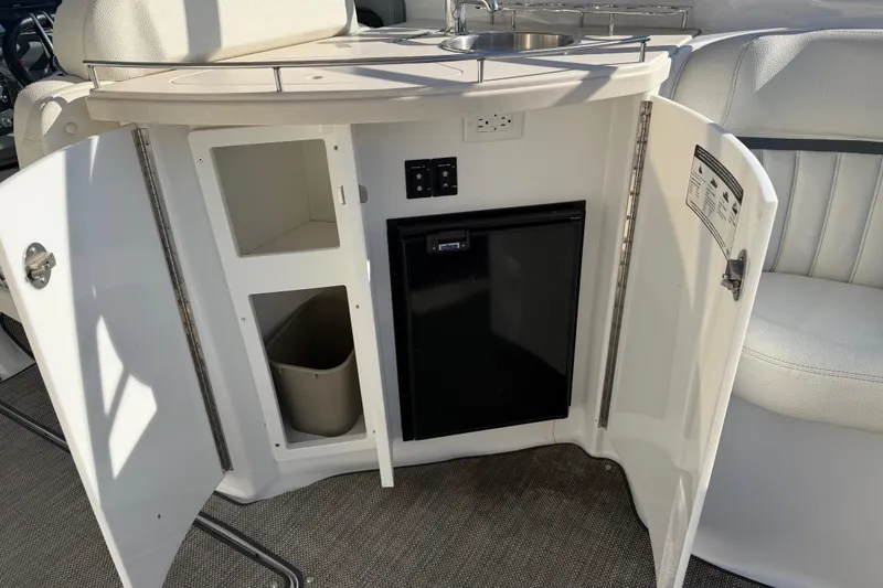 Slide: The Image of 2019 Cobalt R35 boat interior with open cabinet, mini fridge, and sink. - 21
