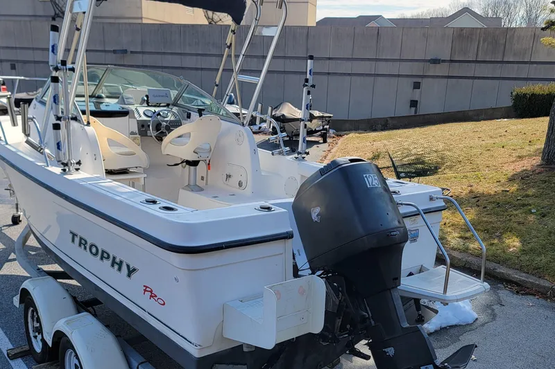 Slide: The Image of 2003 Trophy 2002 Walkaround boat with outboard motor, parked on a trailer. - 3