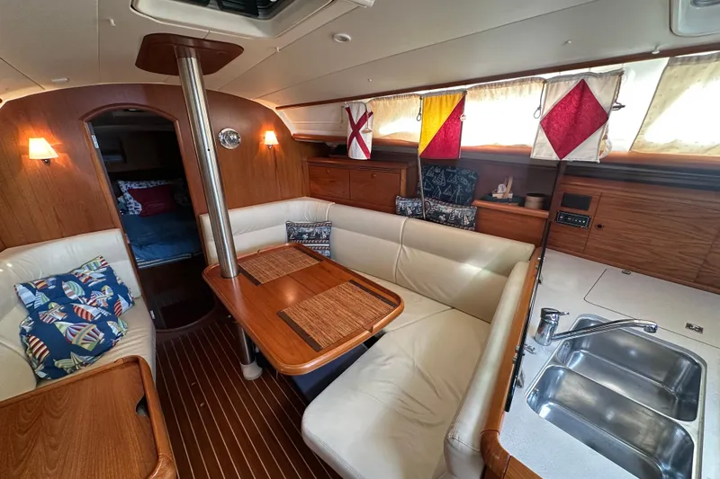 Slide: The Image of Interior of 2004 Jeanneau Sun Odyssey 35 sailboat with cozy seating and nautical decor. - 11