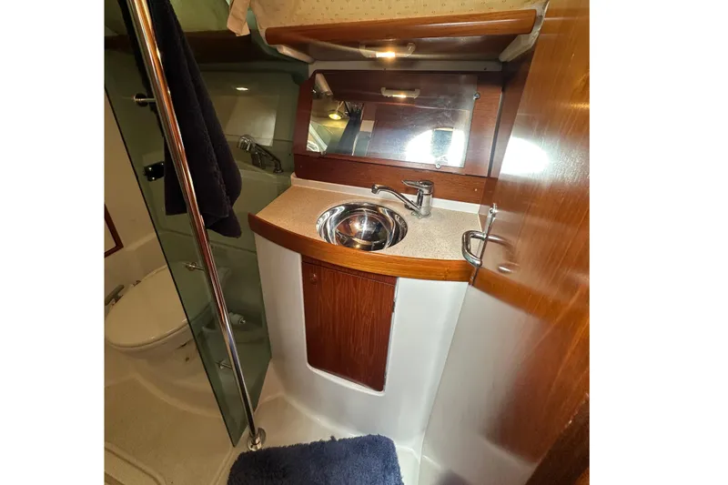 Slide: The Image of Bathroom interior of 2004 Jeanneau Sun Odyssey 35 yacht, featuring sink and mirror. - 15