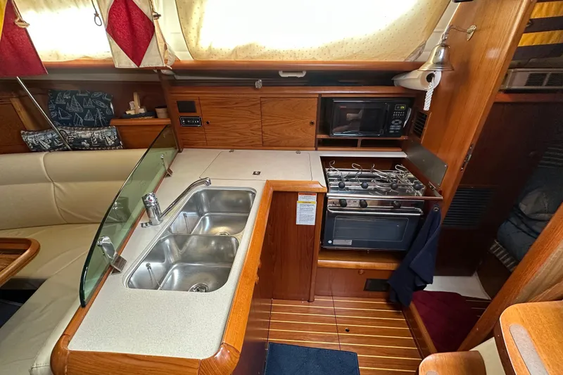 Slide: The Image of Interior of 2004 Jeanneau Sun Odyssey 35 yacht kitchen with stove, sink, and microwave. - 17