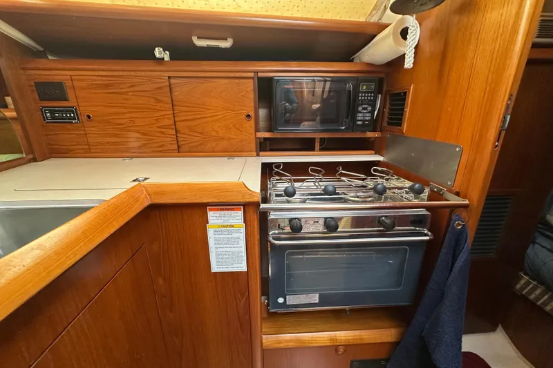 Slide: The Image of 2004 Jeanneau Sun Odyssey 35 yacht kitchen with stove, oven, and microwave. - 23