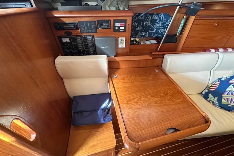 Slide: The Image of Interior of 2004 Jeanneau Sun Odyssey 35 sailboat with navigation station and wooden table. - 25